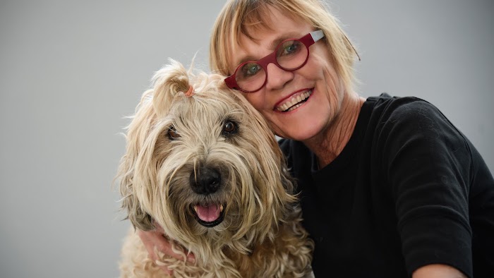 Dueña y perro posando para la cámara